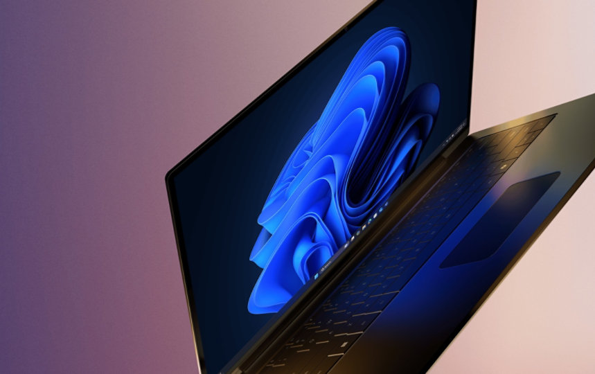 A laptop open with the Microsoft blue bloom on home screen