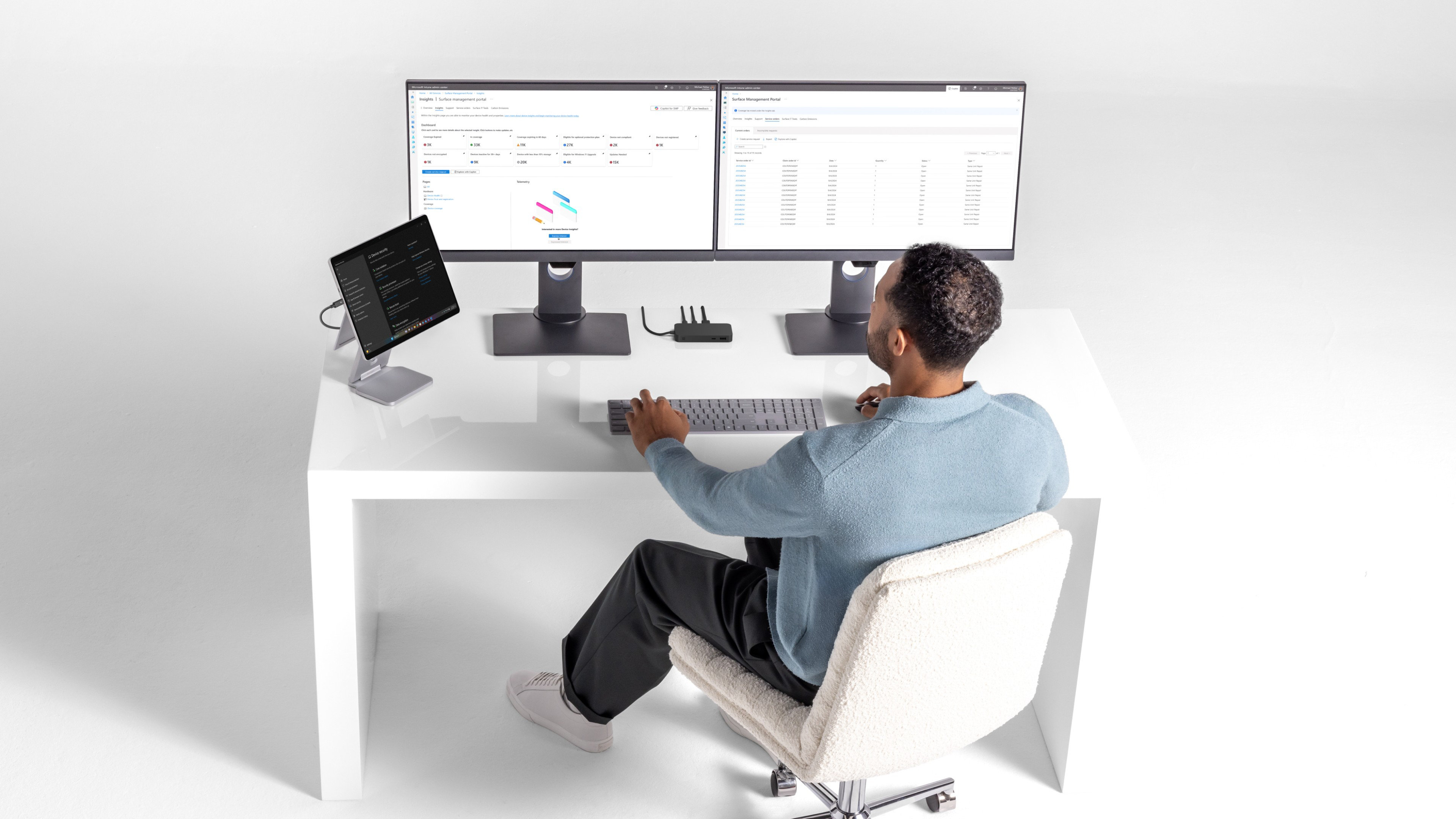 A man sitting at his desk using an elevated stand for his Surface device