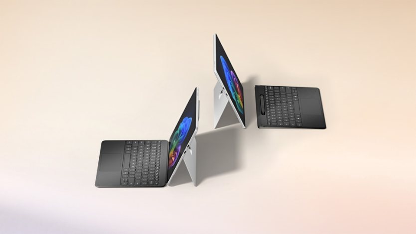 Kaksi värillistä Surface 2-in-1 -laitetta sekä jalusta ja irrotettava näppäimistö
